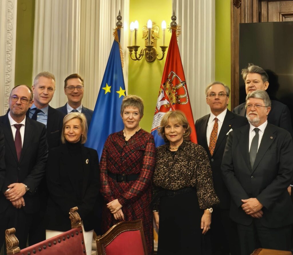 Șerban Dimitrie Sturdza și Elvira Kovács alături de membri ai Comisiei de Afaceri Externe în fața steagurilor Uniunii Europene și Serbie